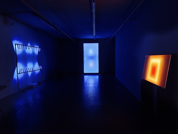 3 light installations in a dark gallery space