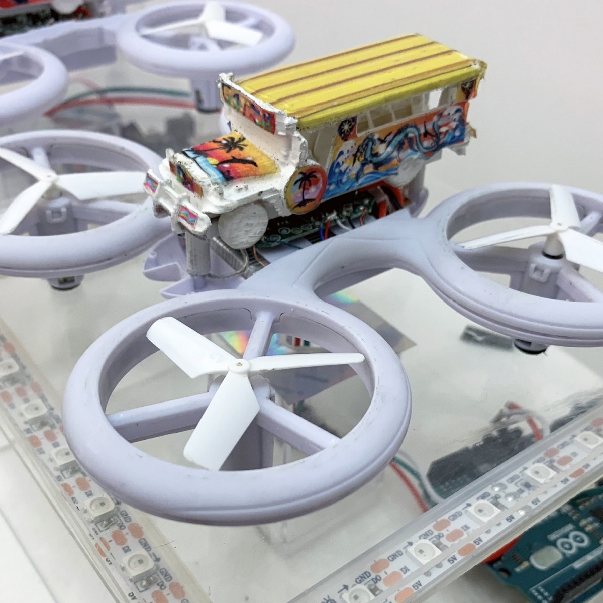 Image of drone with toy bus on top of it.