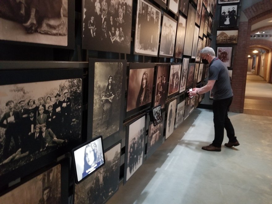 A man interacting with the "Tower of Faces" gallery using an iPad