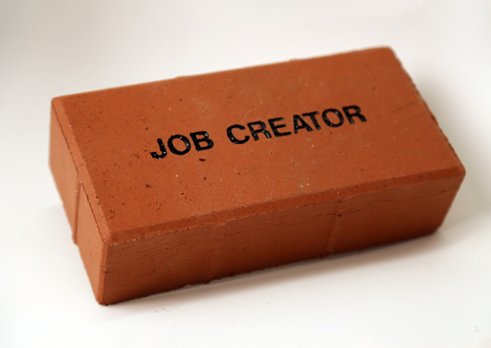 a brick with "job creator" printed on it