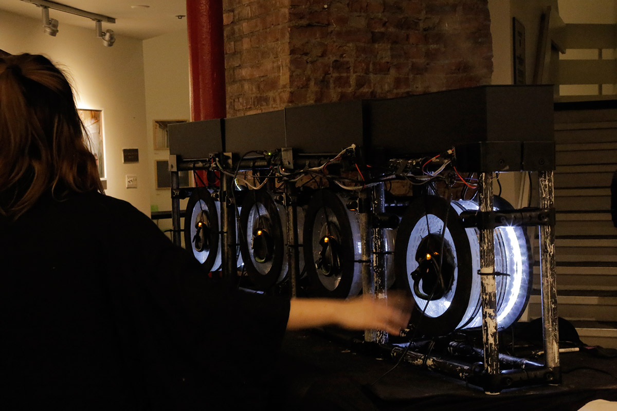 an industrial looking musical instrument made up of 4 circular motors that light up