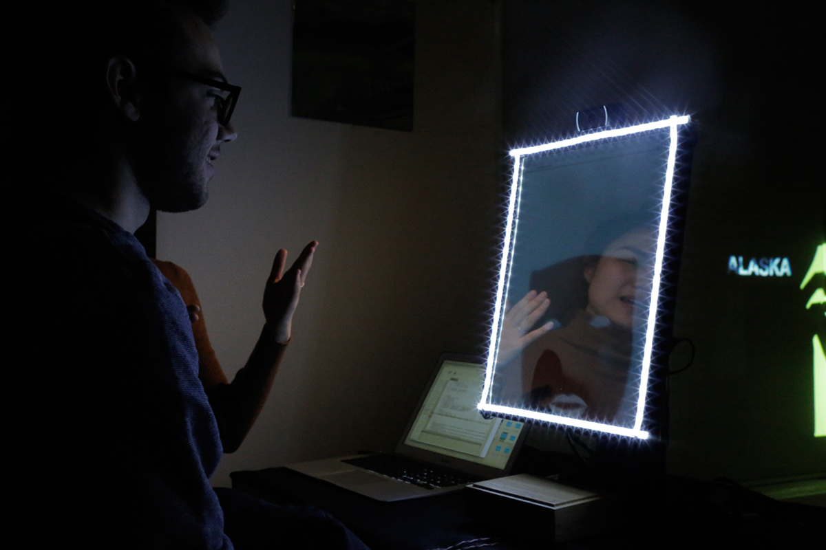 A man looking at a mirror that has a LED border light up