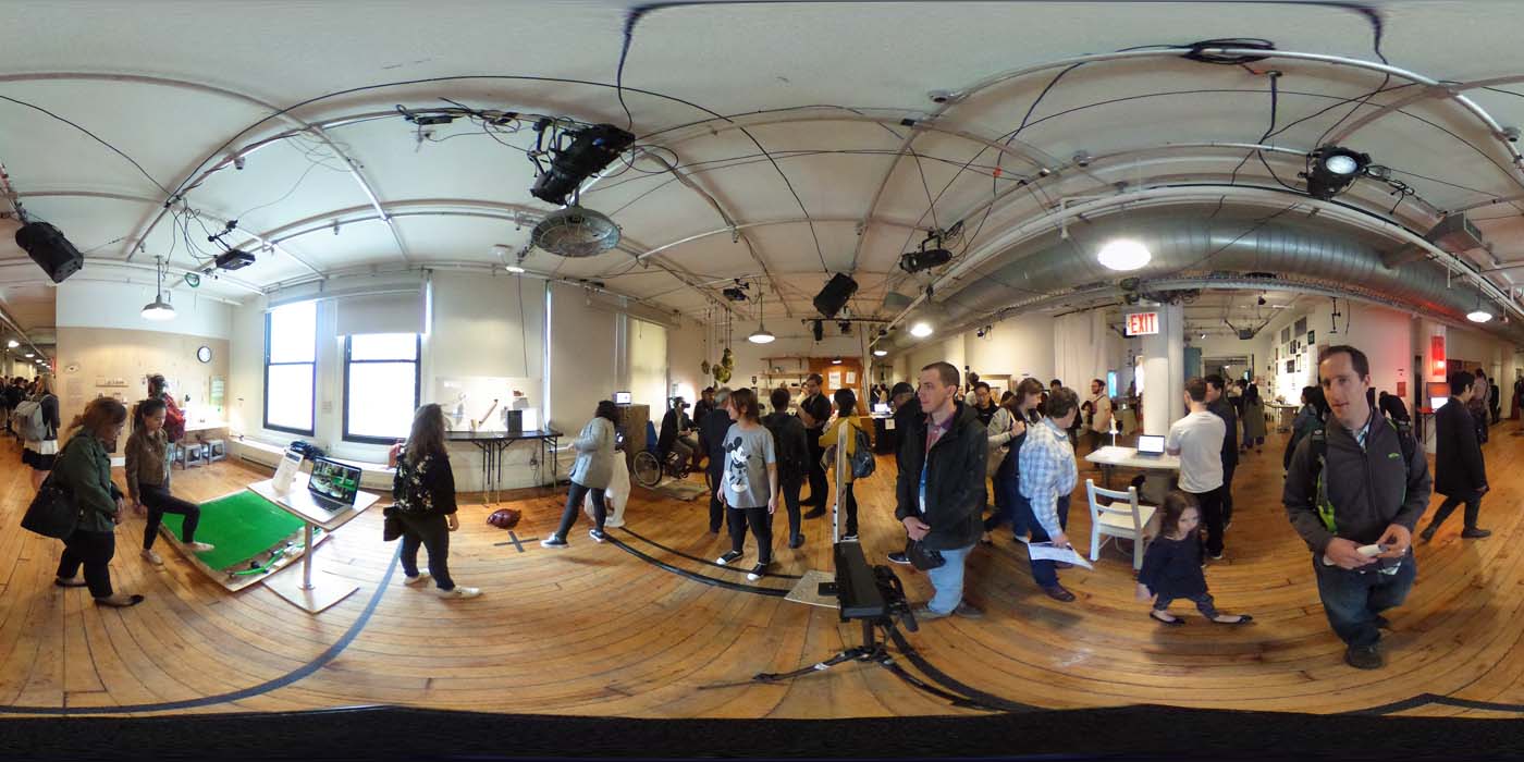 a 360 image of the hallway and people standing by projects at the show
