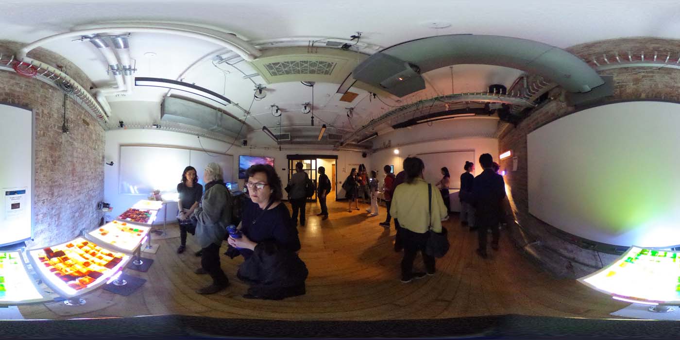 a 360 image of the hallway and people standing by projects at the show