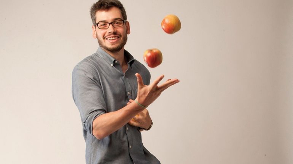 a man throwing and juggling 2 apples