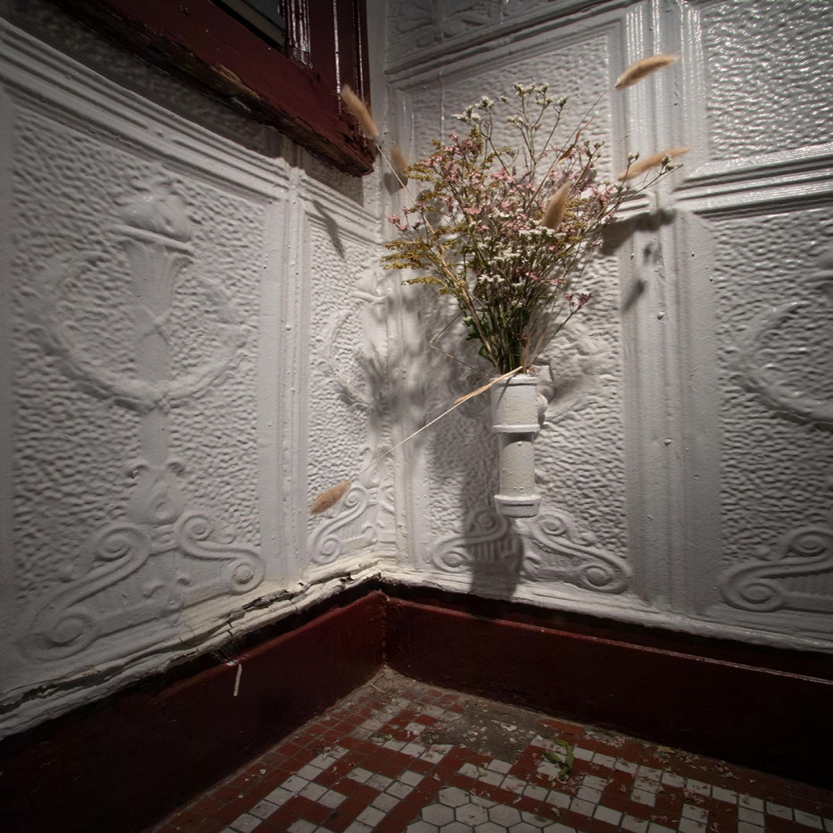 photo of a corner with dried flowers in a wall pipe