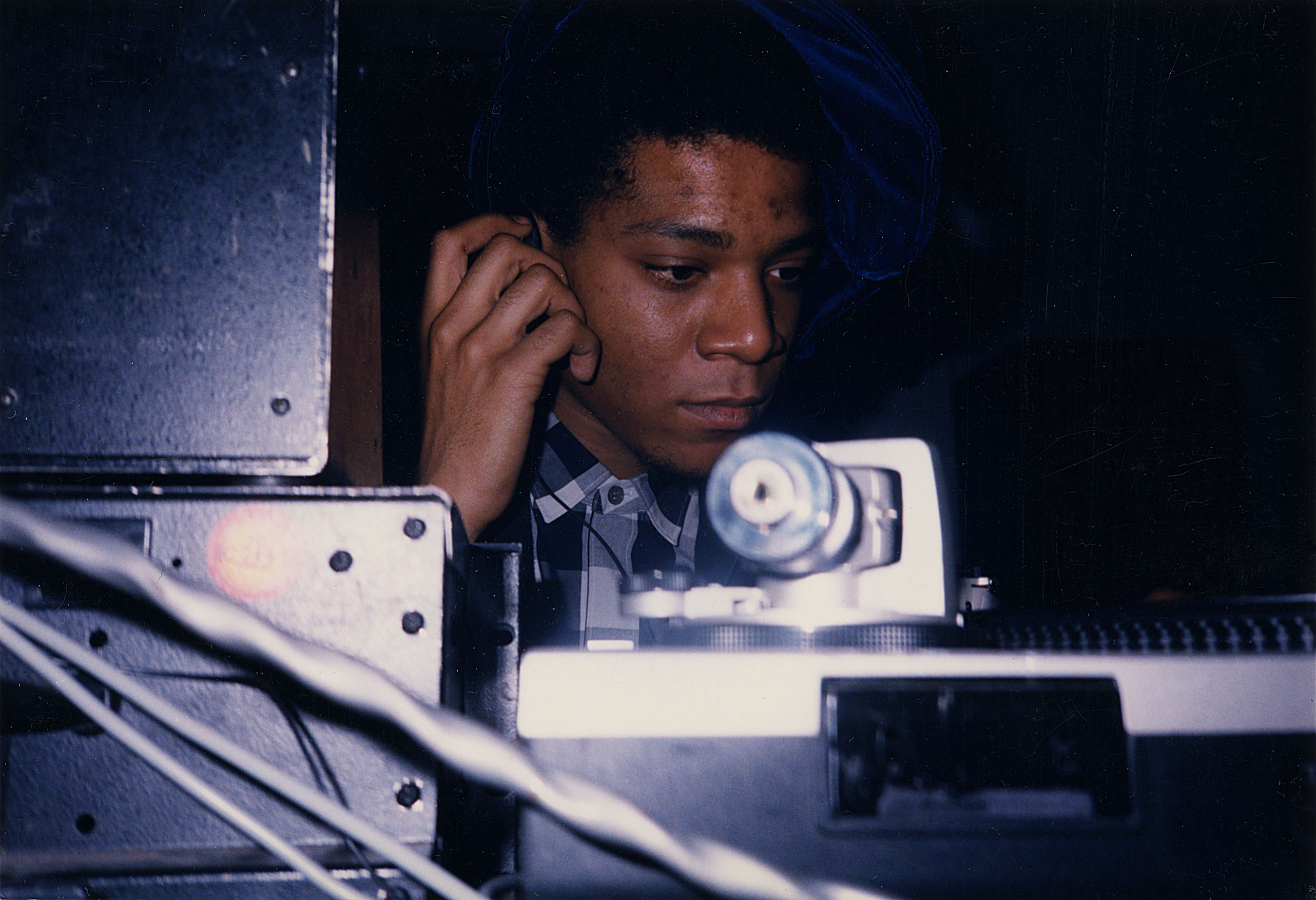 JEAN-MICHEL BASQUIAT DJ-ING IN THE LOUNGE AT AREA, 1986