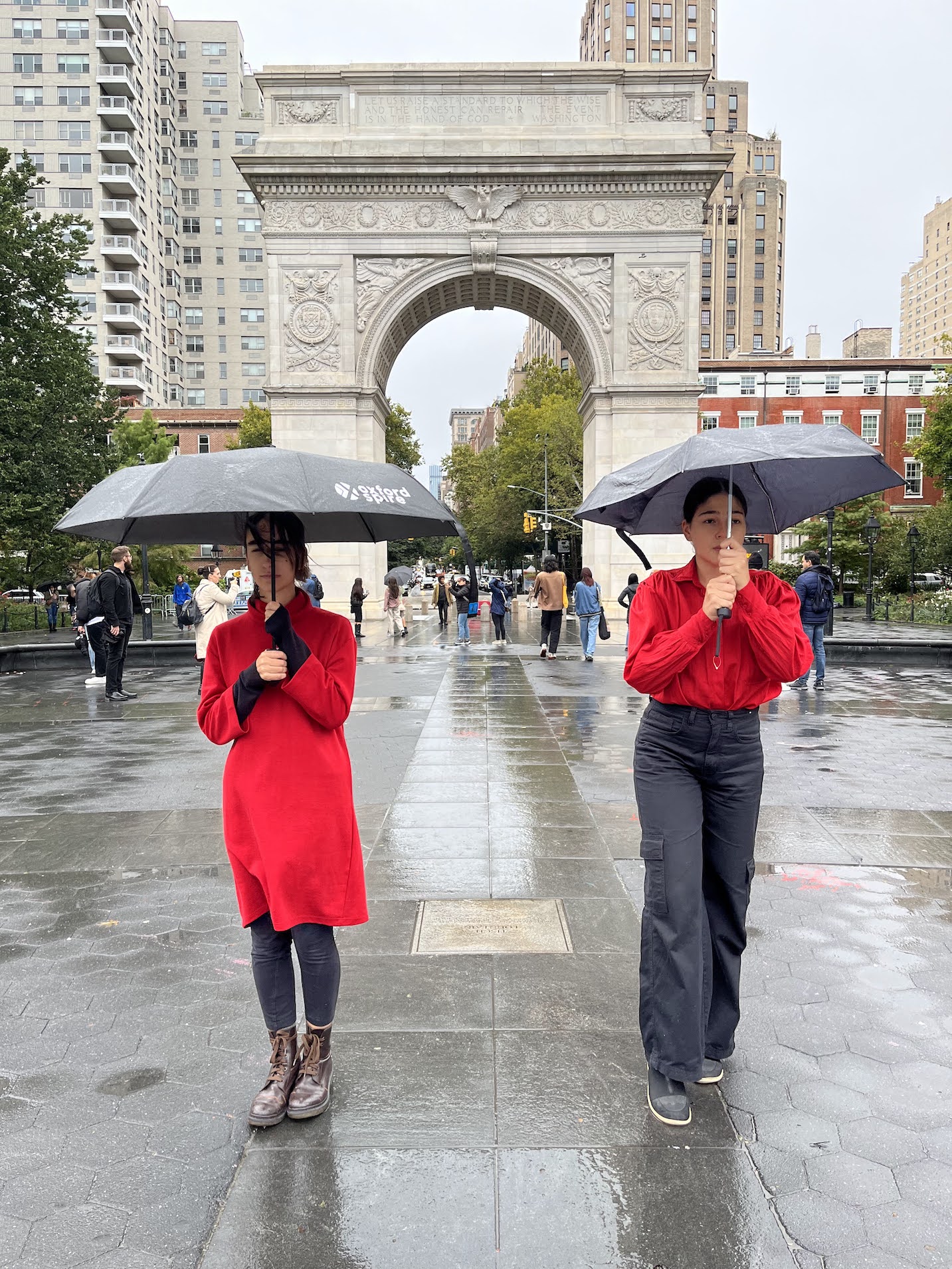 two people standing next to each other in the rain with umbrellas