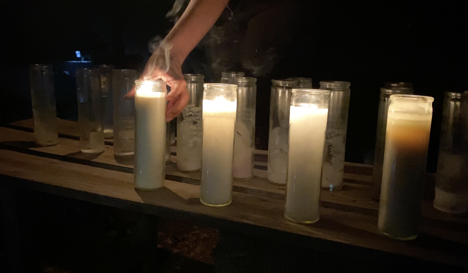 Prayer candles being lit one by one