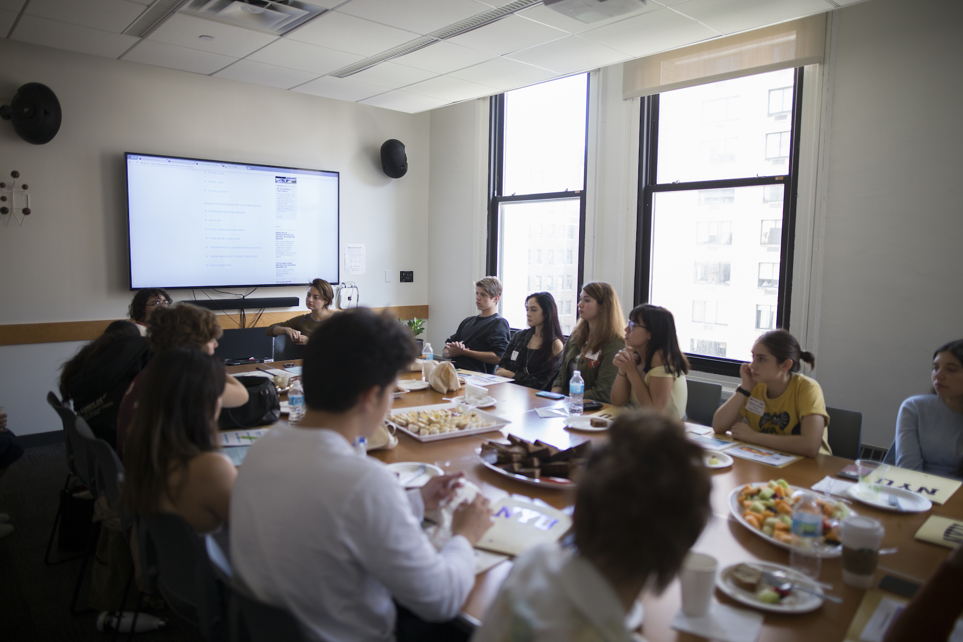 students sitting at round table listening to presentation