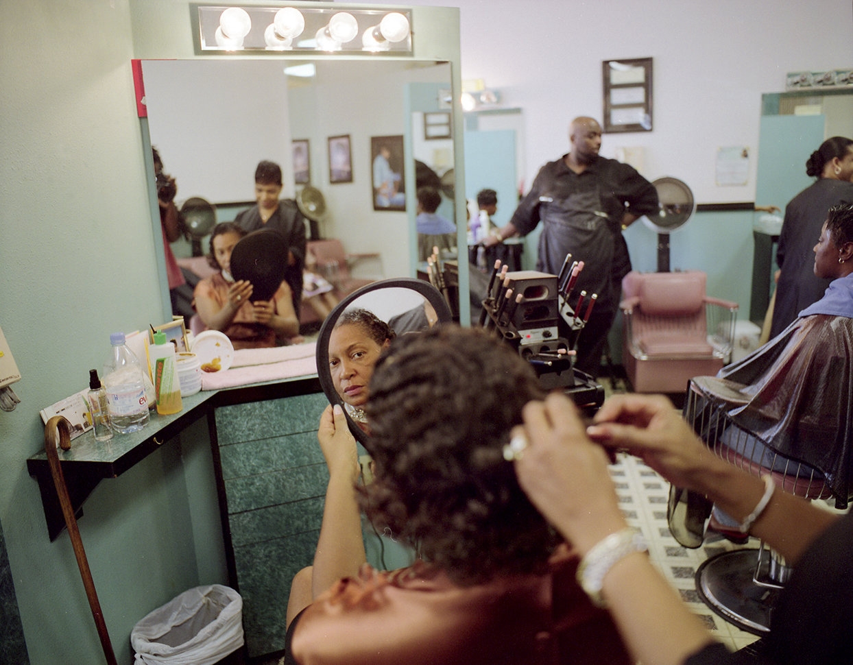 photograph of a woman in a beauty shop looking in a mirror