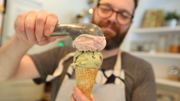 Sugar Hill Creamery co-owner Nick Larsen scoops strawberry-basil and blackberry-pistachio flavors. Photo Credit: Linda Rosier