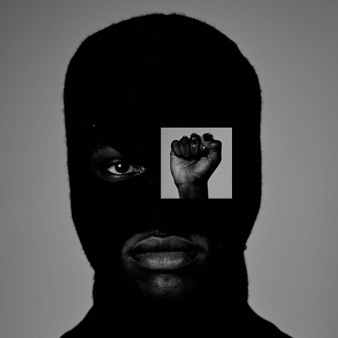 a young black man in a balaklava stares directly into the camera in a close up with a cut our of a raised fist over one eye