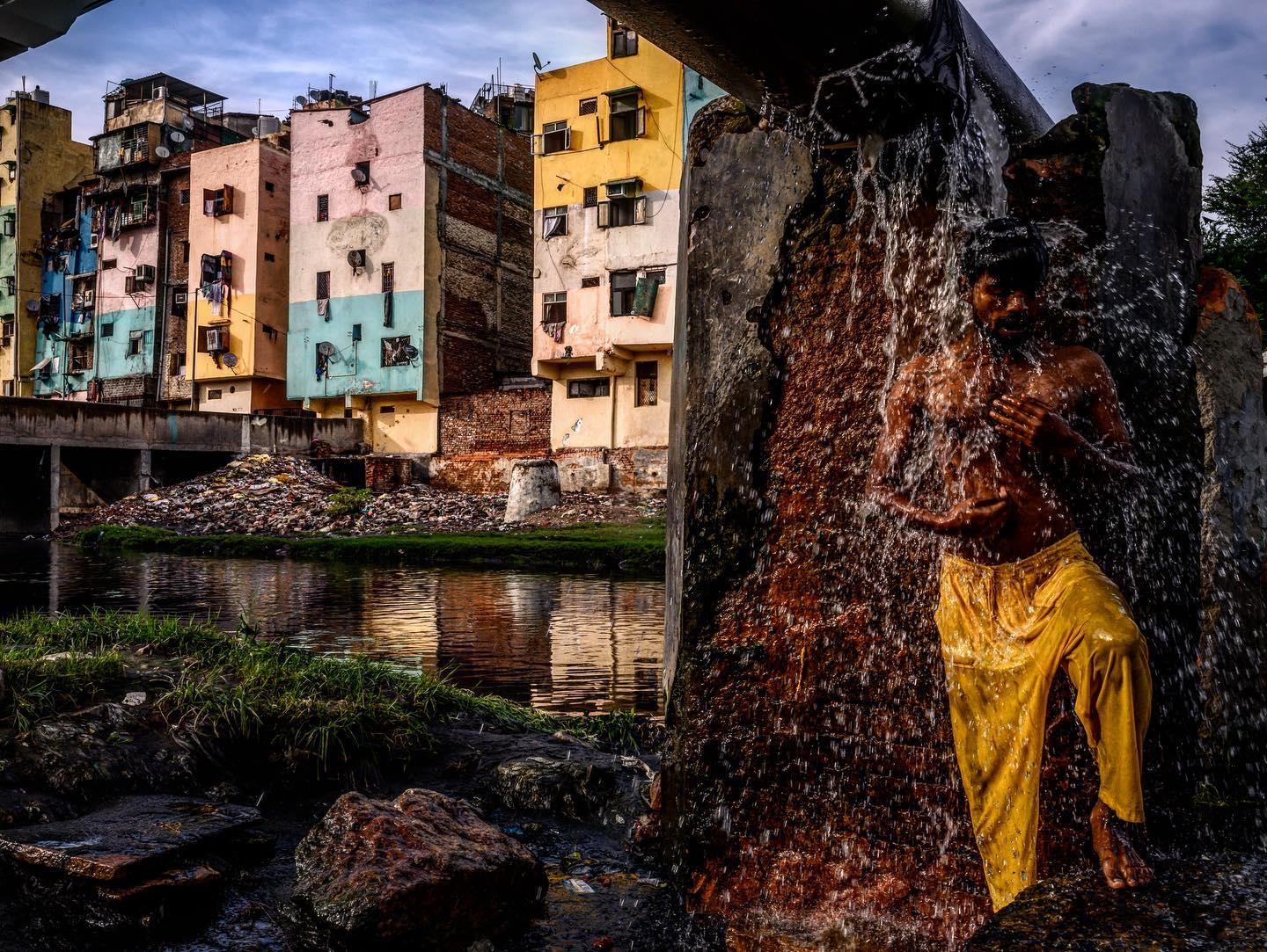 8/6/2019 Delhi, India. A man bathed in water spouting from a broken municipal water line along the Barapullah waterway in New Delhi. Bryan Denton for the New York Times.