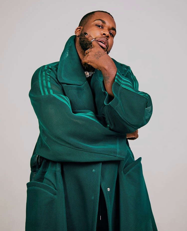 Eric in green ivy park track suit with left hand under his chin