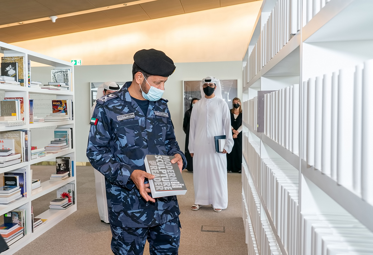 Sharjah Police (SP) member looks onward at installation of books by Prof. Wafaa Bilal
