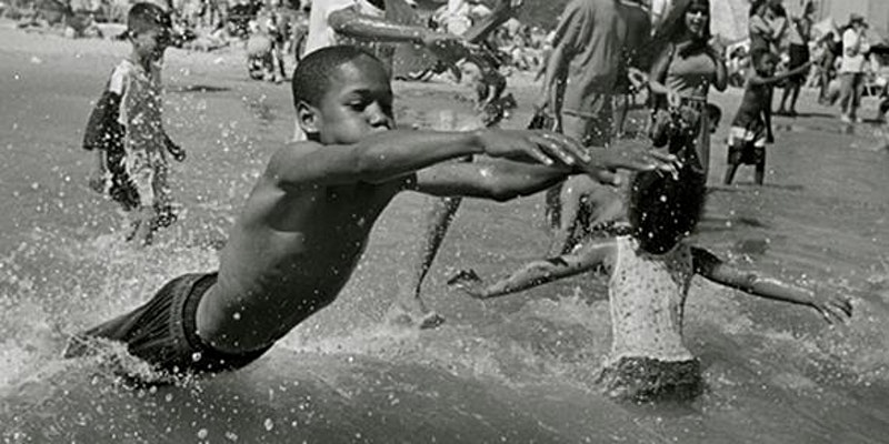 young boys playing in a public fountain