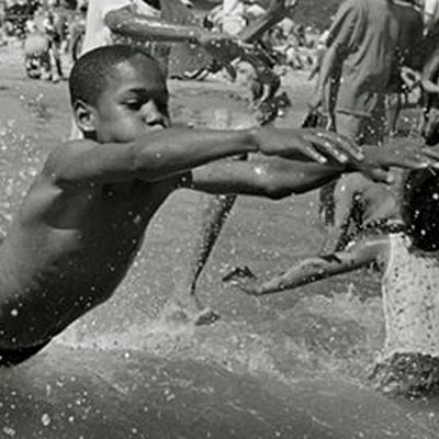 young boys playing in a public fountain