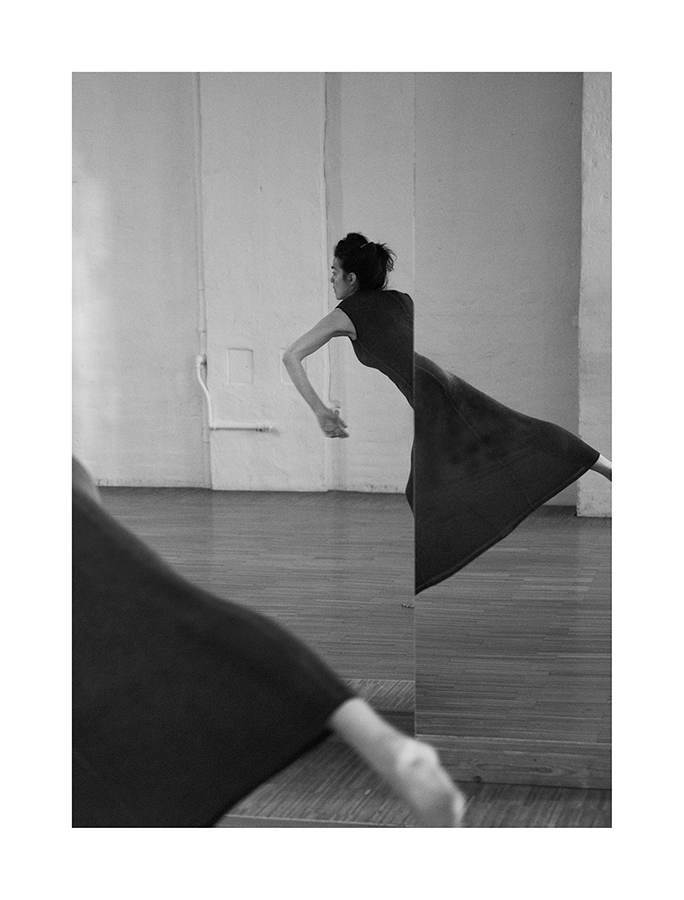 interior black and white portrait of a dancer in pose reflected in a mirror