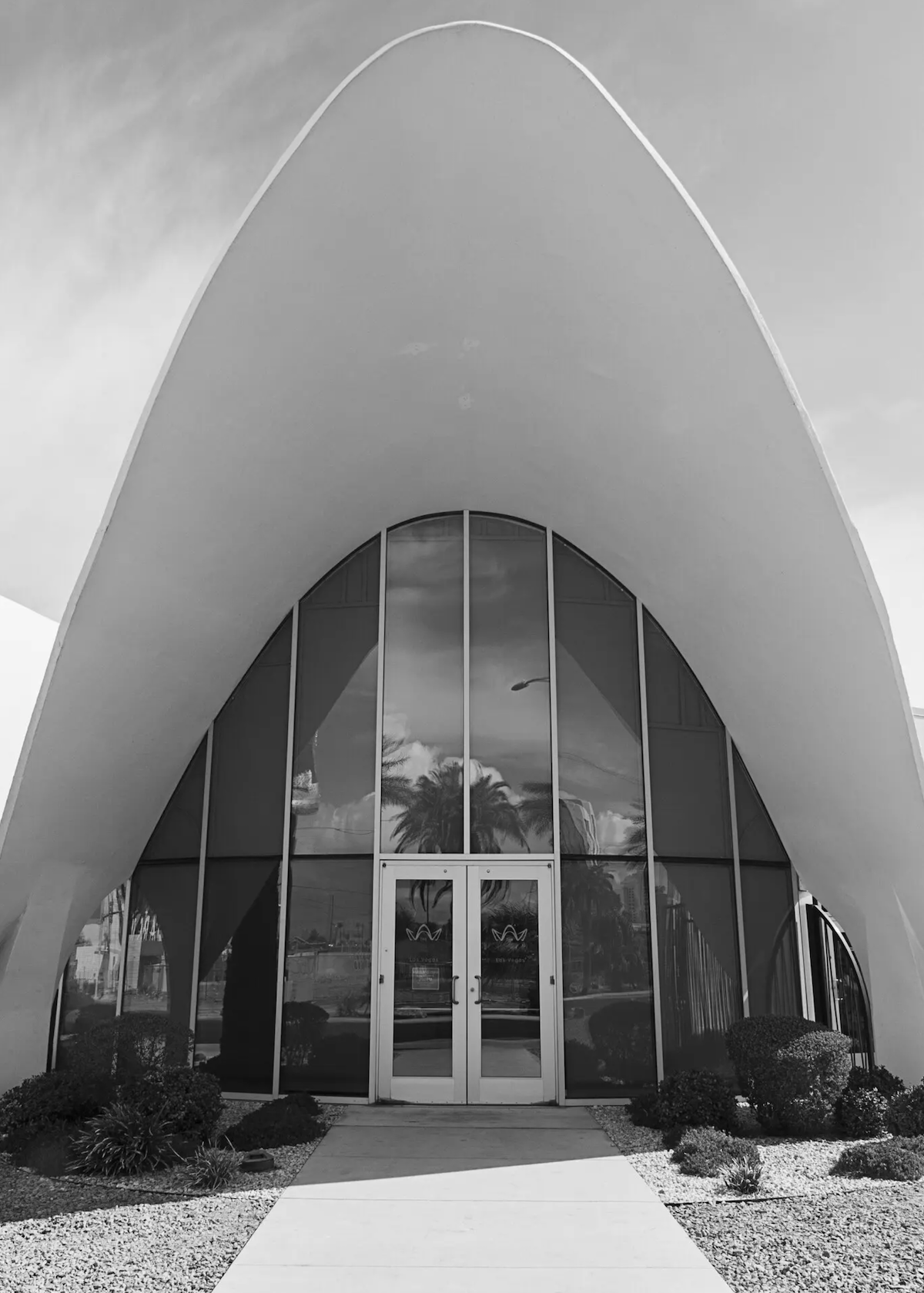 outdoor black and white photo of building facade shaped like a pointed seashell or similar style