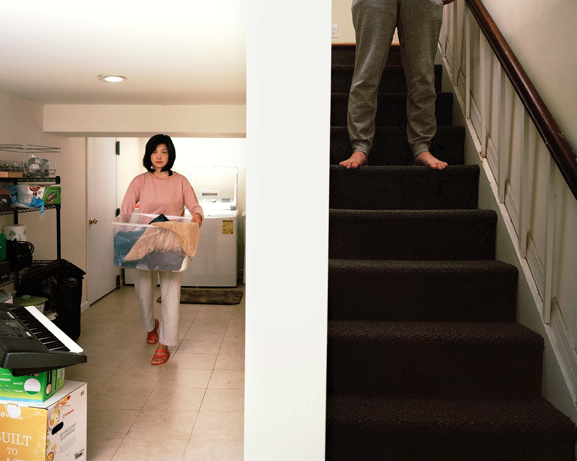 person in basement, frame split by wall, person on stair