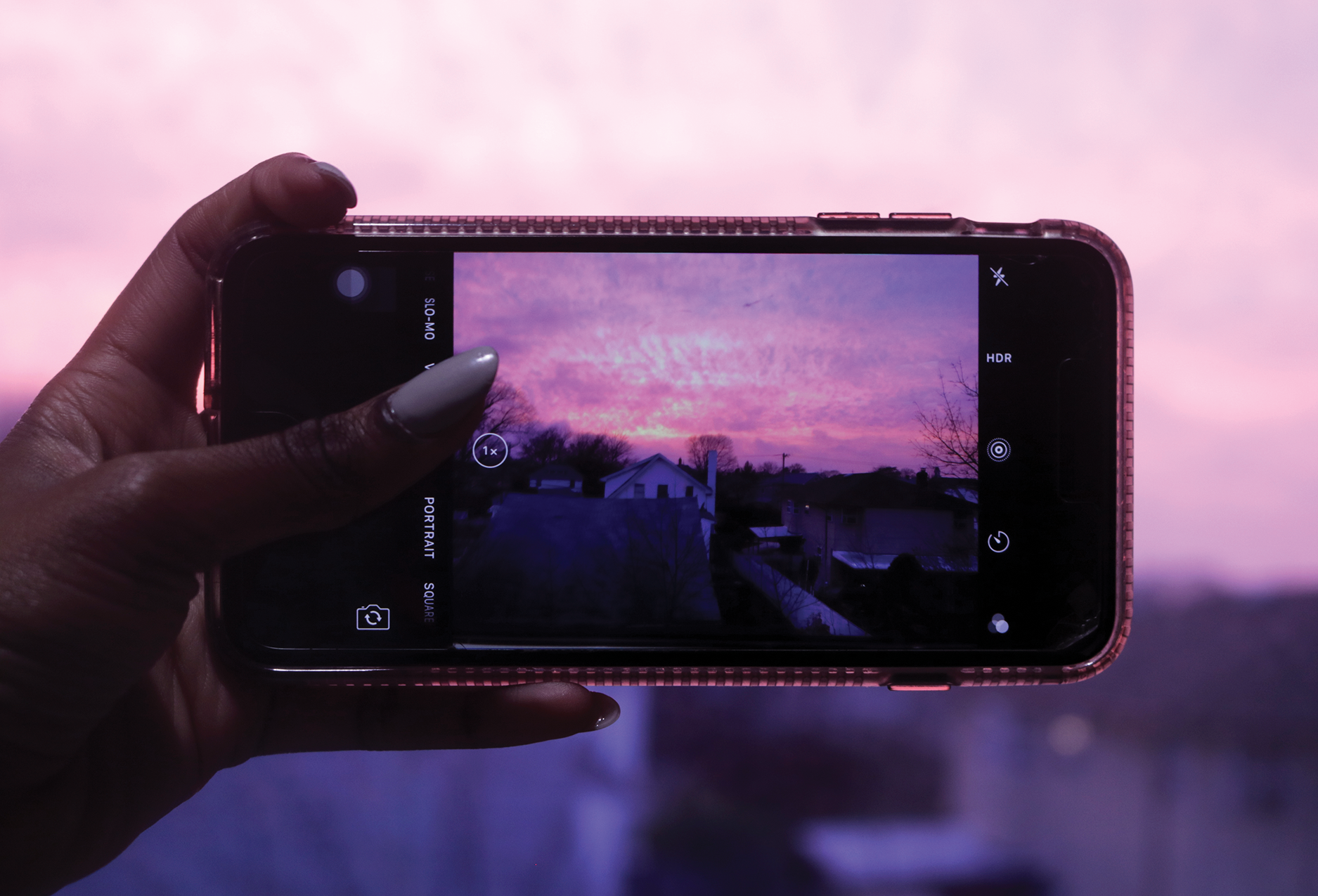 A student photographs the cityscape with her mobile phone.