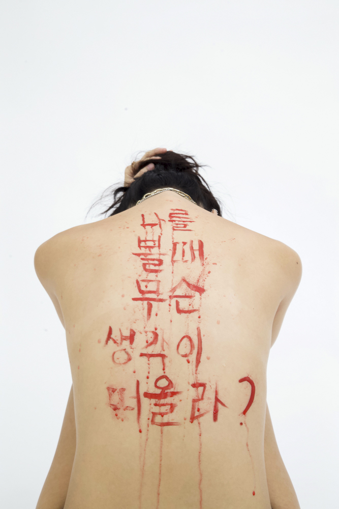 portrait of a woman's back w/foreign characters written on it