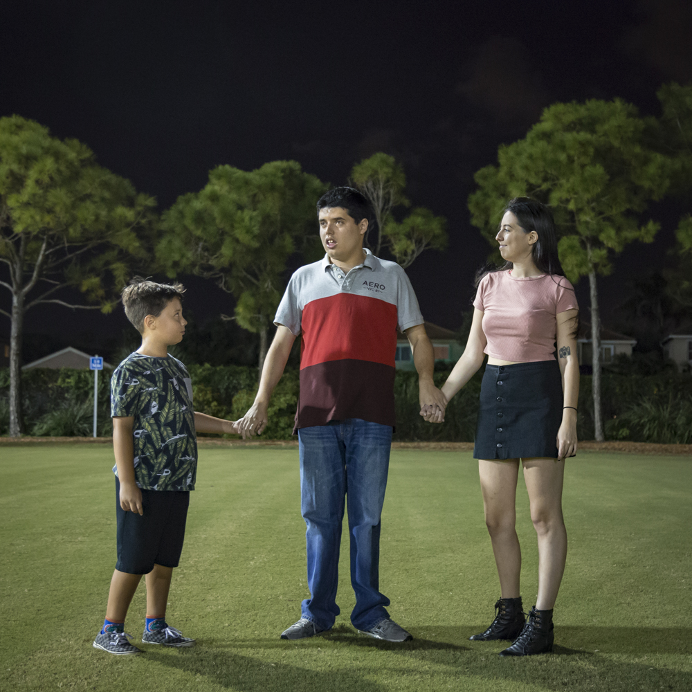 portrait of a family standing in a field, next to a letter addressed to a sibling of a person with autism