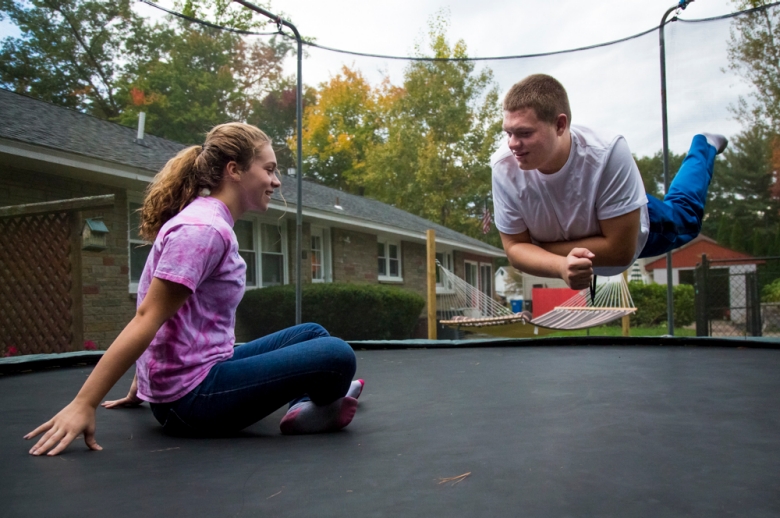 portrait of a pair of siblings on a trampoline