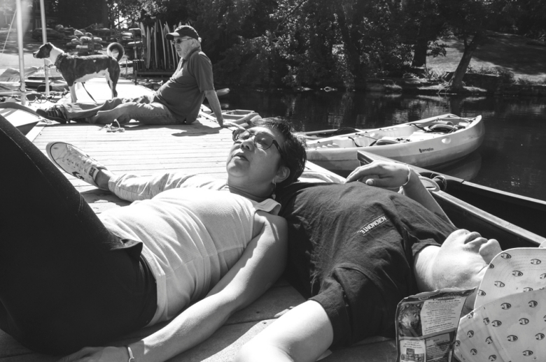 black and white photo of people lying on a dock