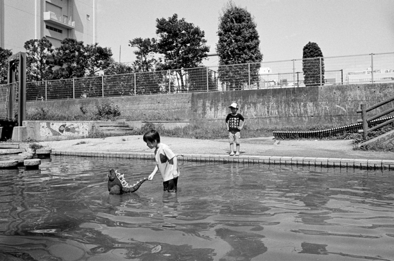 black and white photo of a child playing in a river