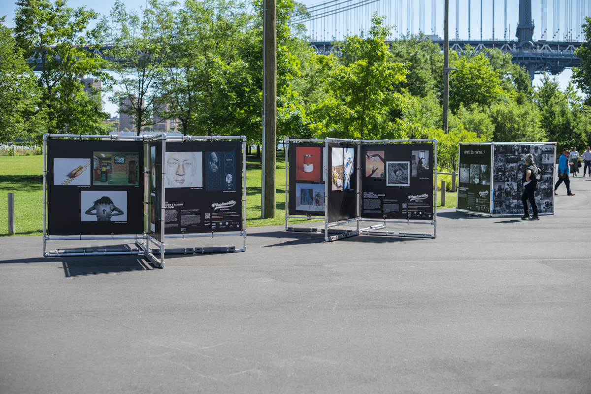 installation view of photoville 2022 at brooklyn bridge park details photographs on install structure against cityscape