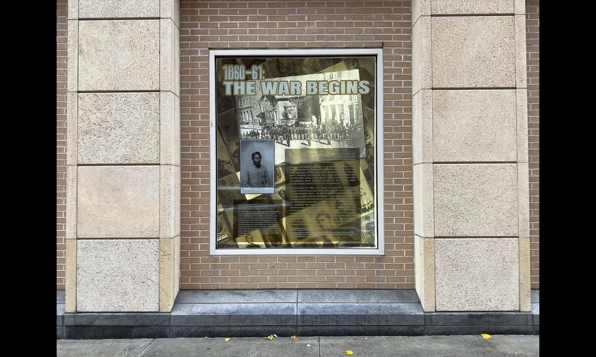 A photograph of a window containing other photographs and text from the book The Black Civil War Soldier by Dr. Deborah Willis