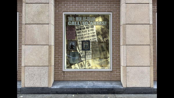 A photograph of a window containing other photographs and text from the book The Black Civil War Soldier by Dr. Deborah Willis