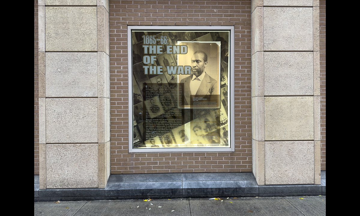 A photograph of a window containing other photographs and text from the book The Black Civil War Soldier by Dr. Deborah Willis