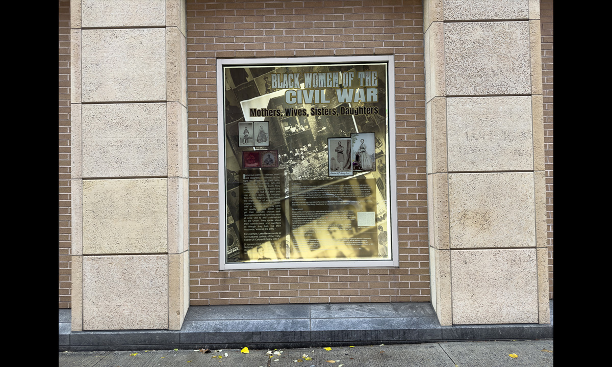 A photograph of a window containing other photographs and text from the book The Black Civil War Soldier by Dr. Deborah Willis