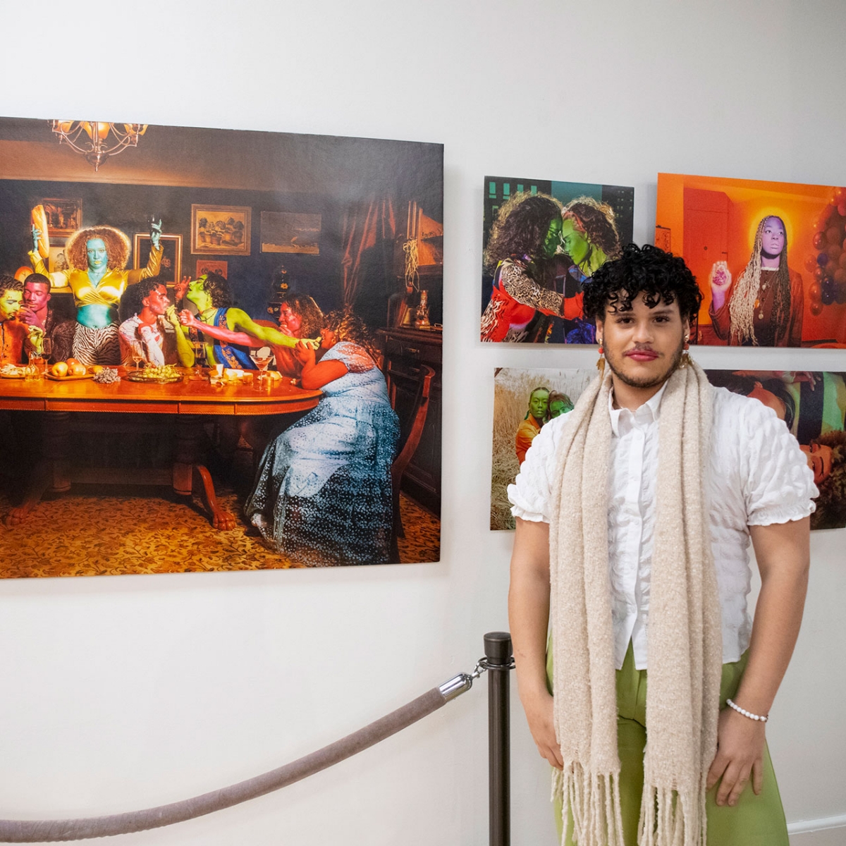 Carlos standing in a gallery in front of own artwork