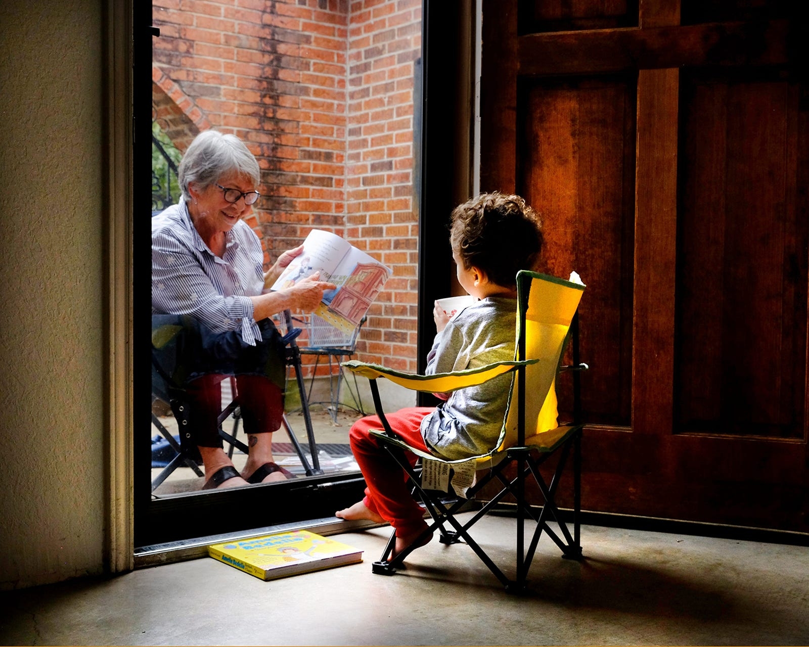 boy and grandma on opposite sides of glass door