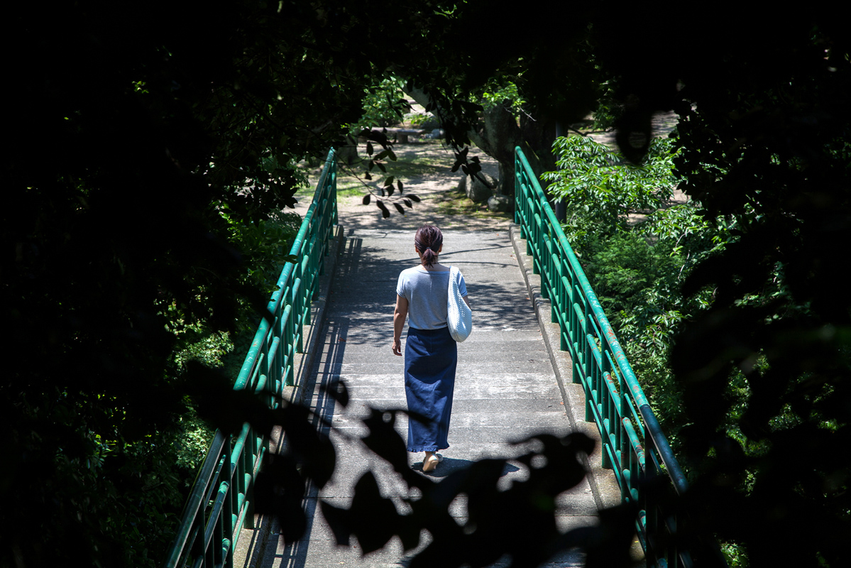 person crossing bridge thru trees
