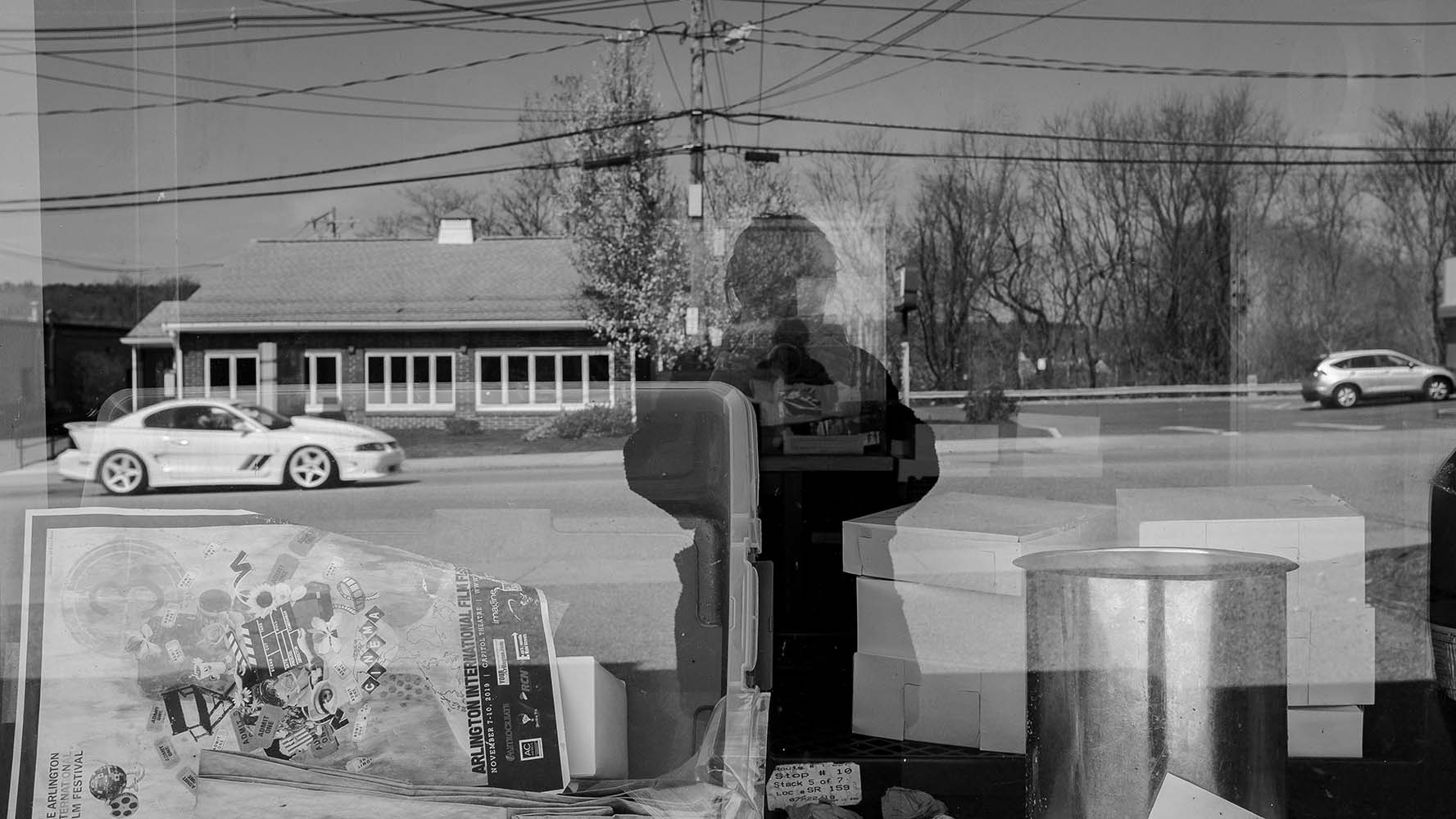 reflections in window with self portrait and car