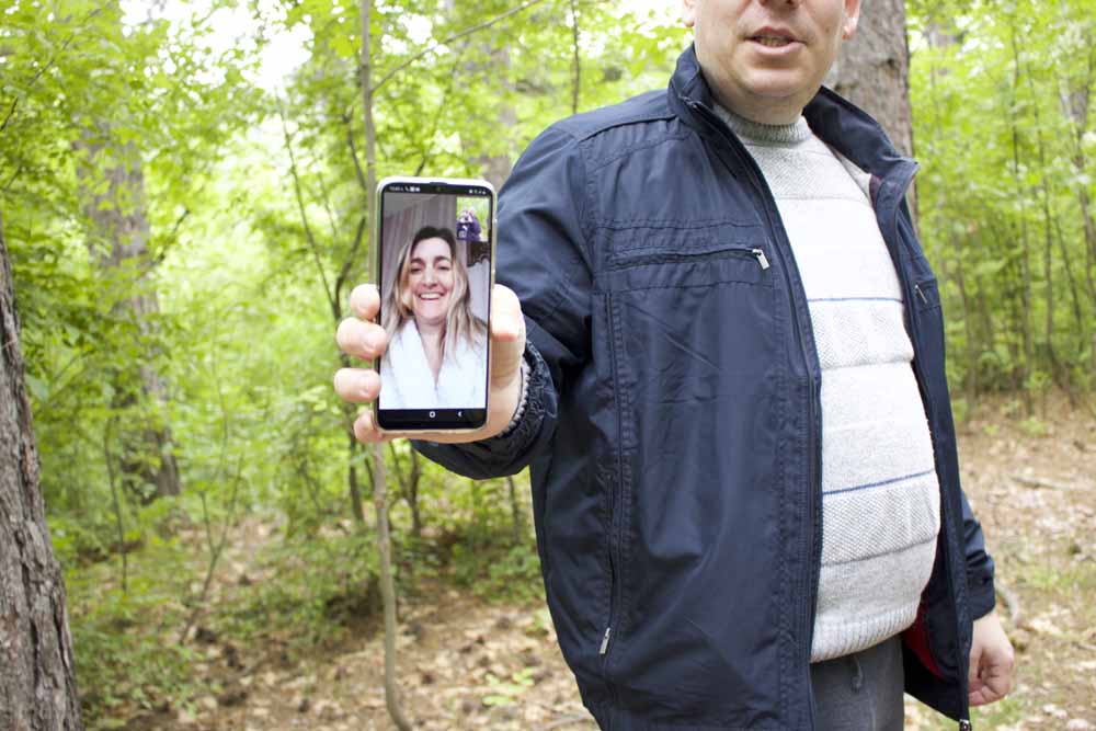 man holding phone with picture of lady