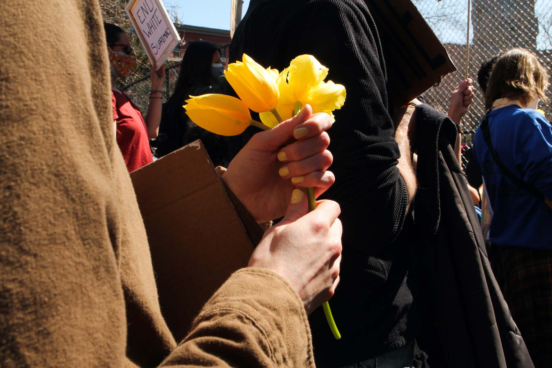 A protester holds orange flowers in her hands