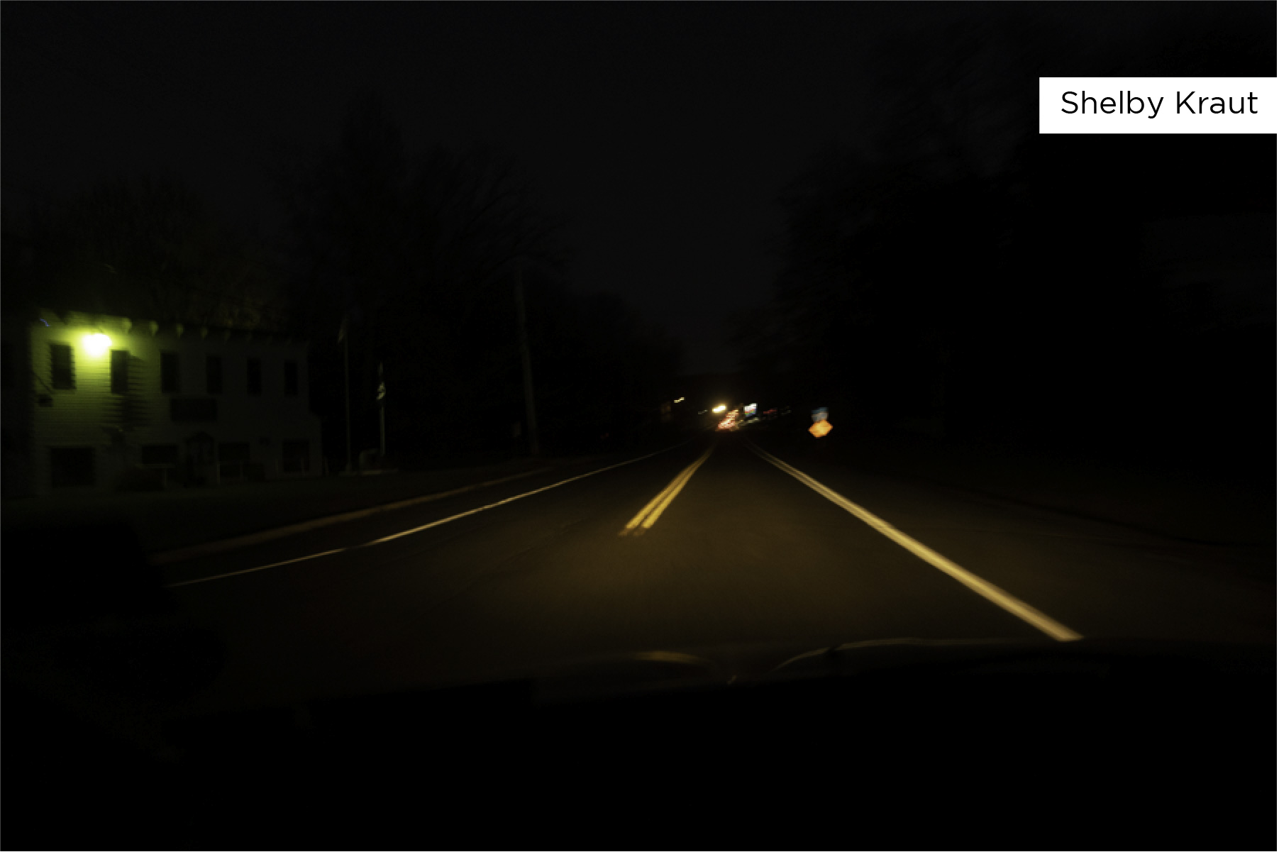 Night scene of a street lit by car headlights