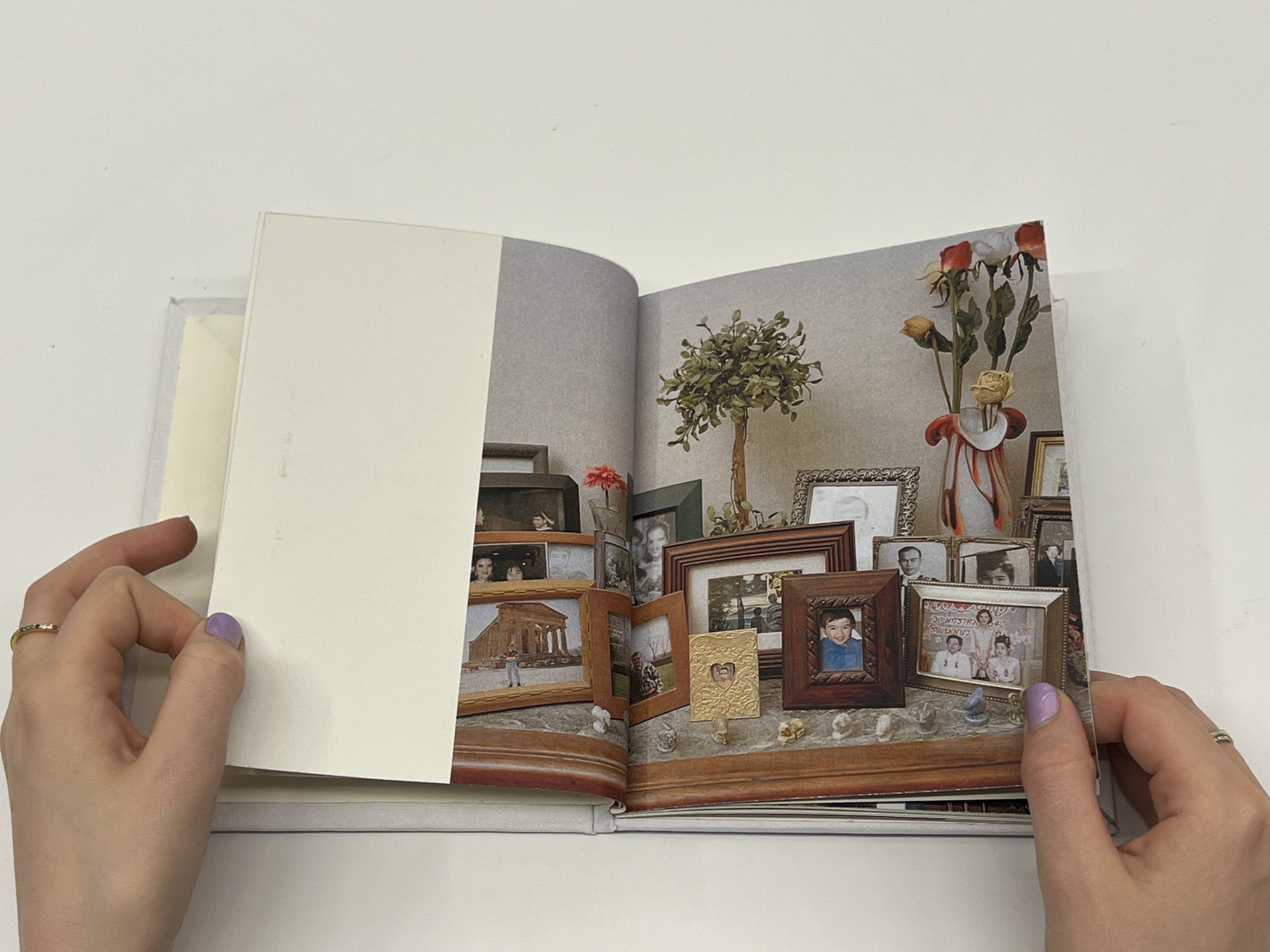 book opened to color photo of framed photos on a tabletop