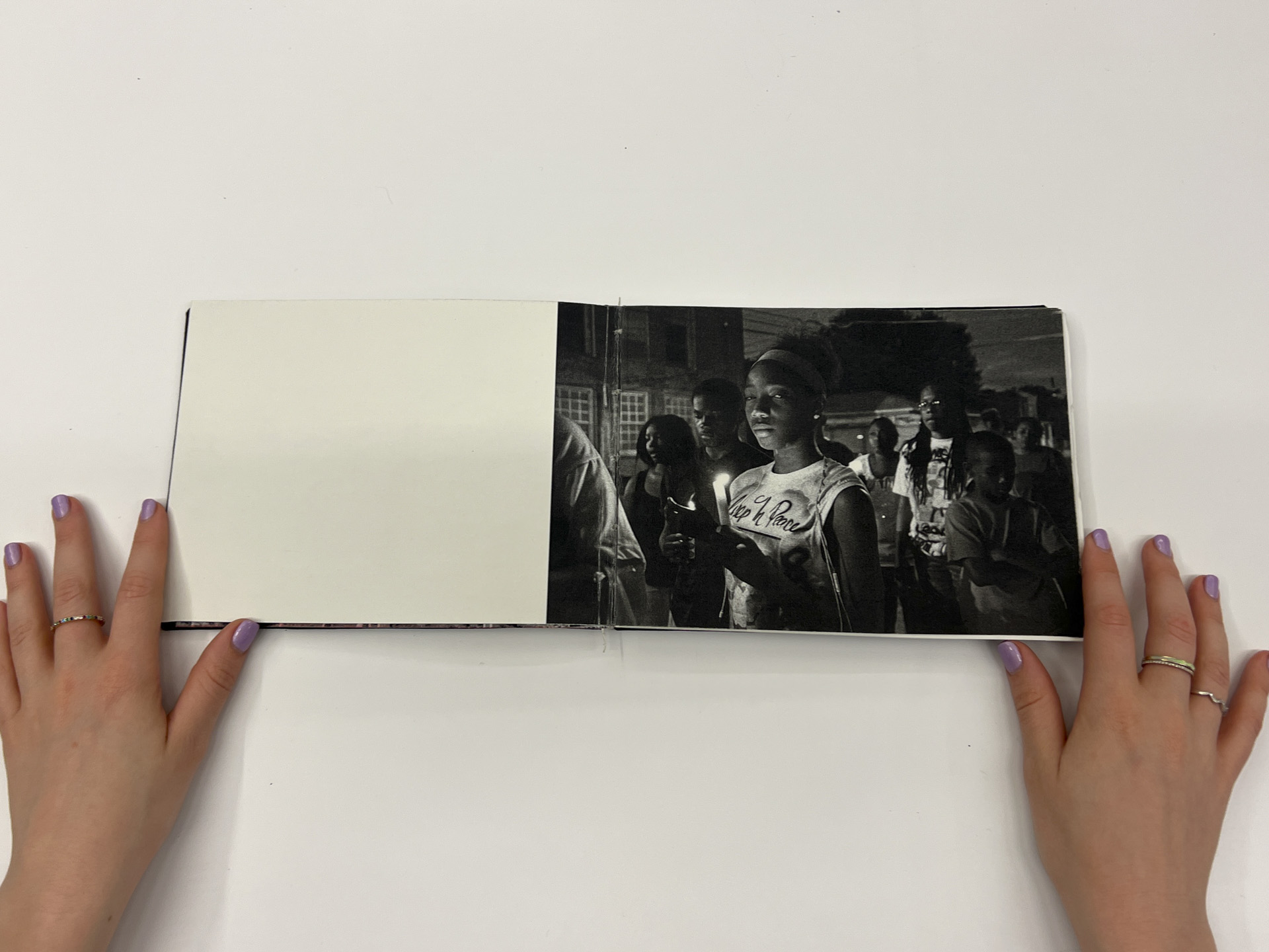 book opened to a black and white photo with people at a candlelight vigil