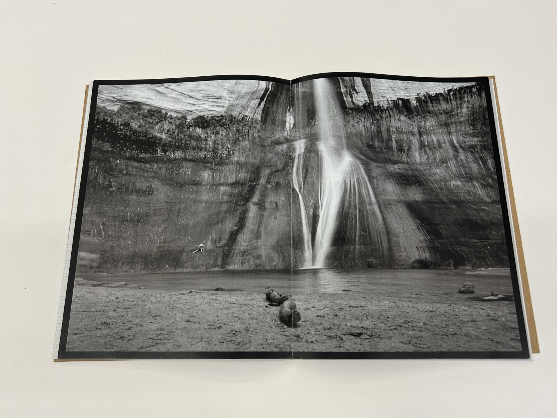 book opened to black and white waterfall outdoor scene