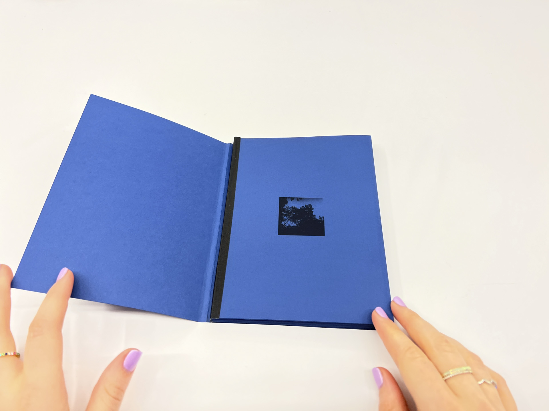 Photo of a handmade book - color is blue, with black line art on cover