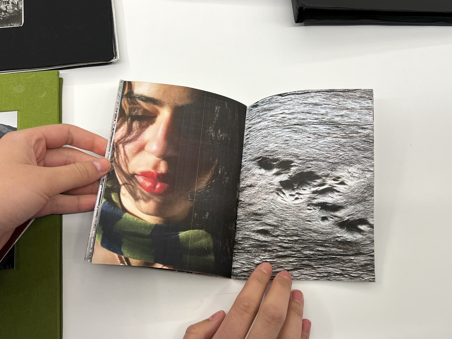 book opened to a photo of a face vs. grey abstract landscape