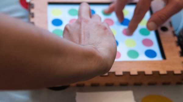 Someone playing twister on a cardboard covered iPad