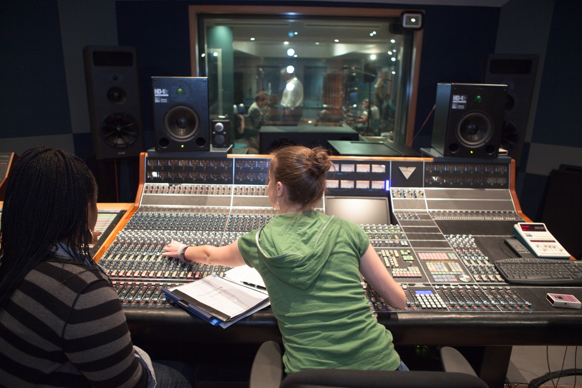 Students in front of an audio console in a recording studio.